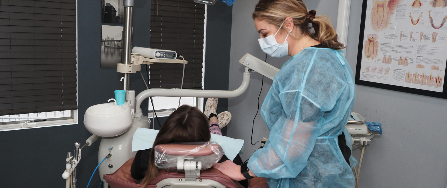 family dentist in Muskegon. Dental hygienist assisting a patient during an exam at a family dentist Muskegon office.